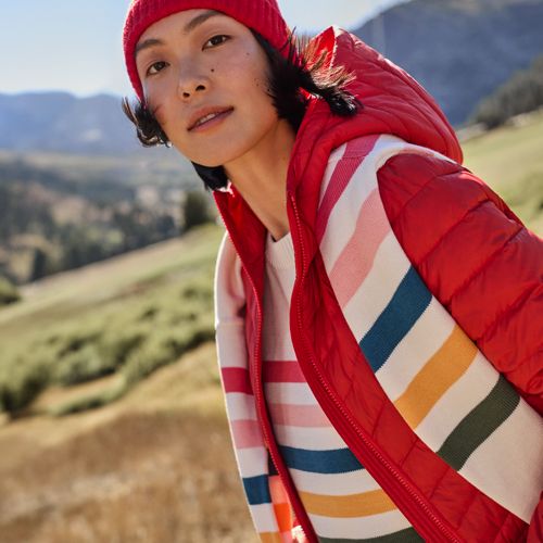 A woman wearing a white sweater with colorful stripes